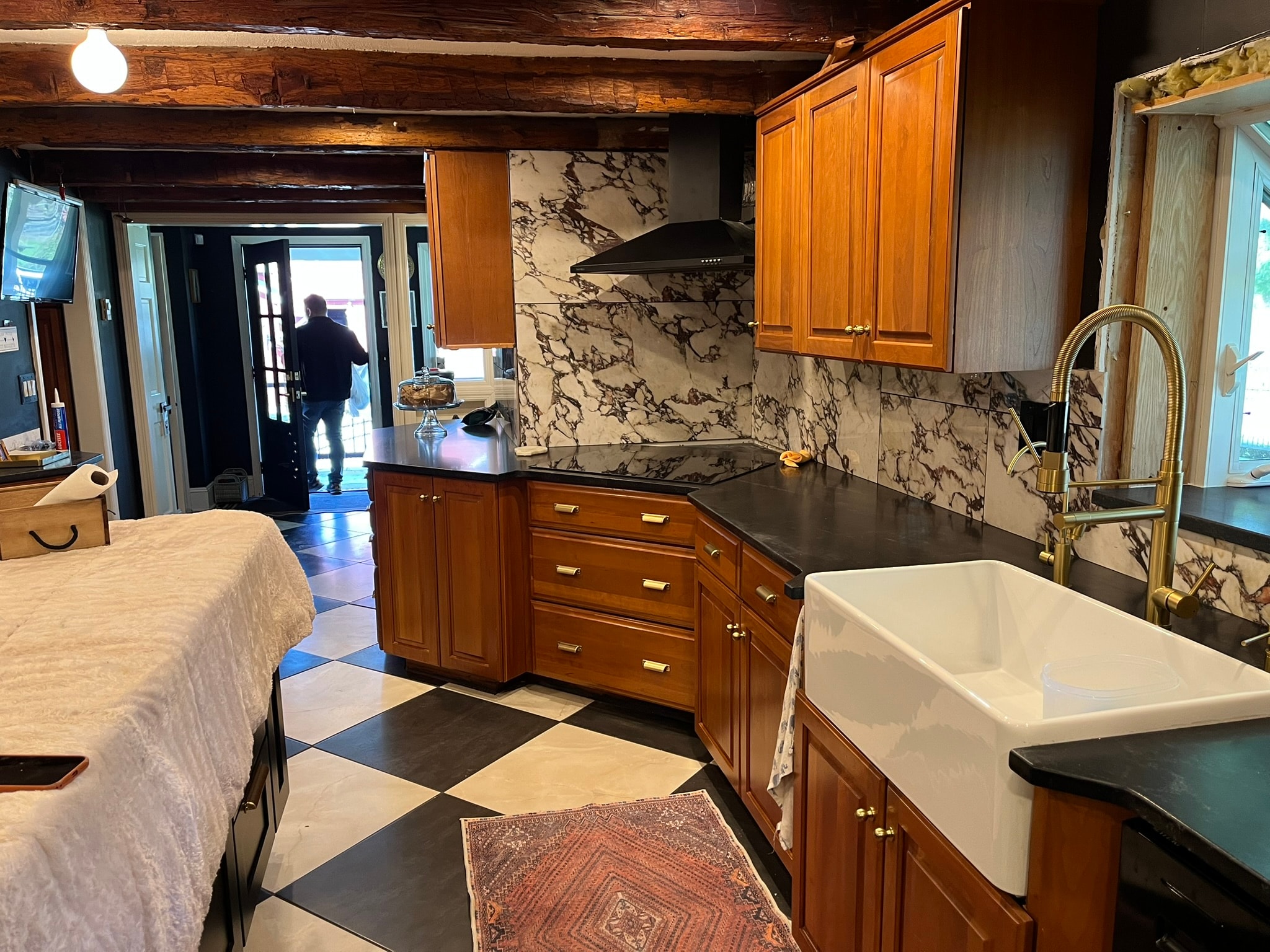 Kitchen with black soapstone countertops and marble backsplash — wide view