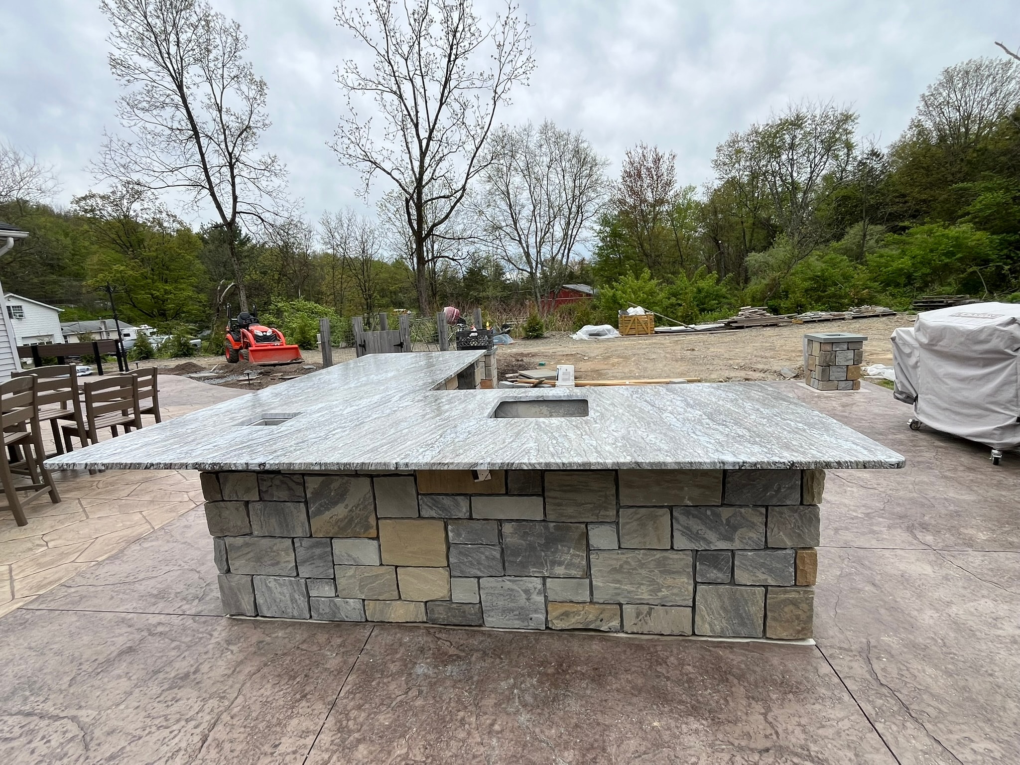 Outdoor granite countertop island on stone base patio