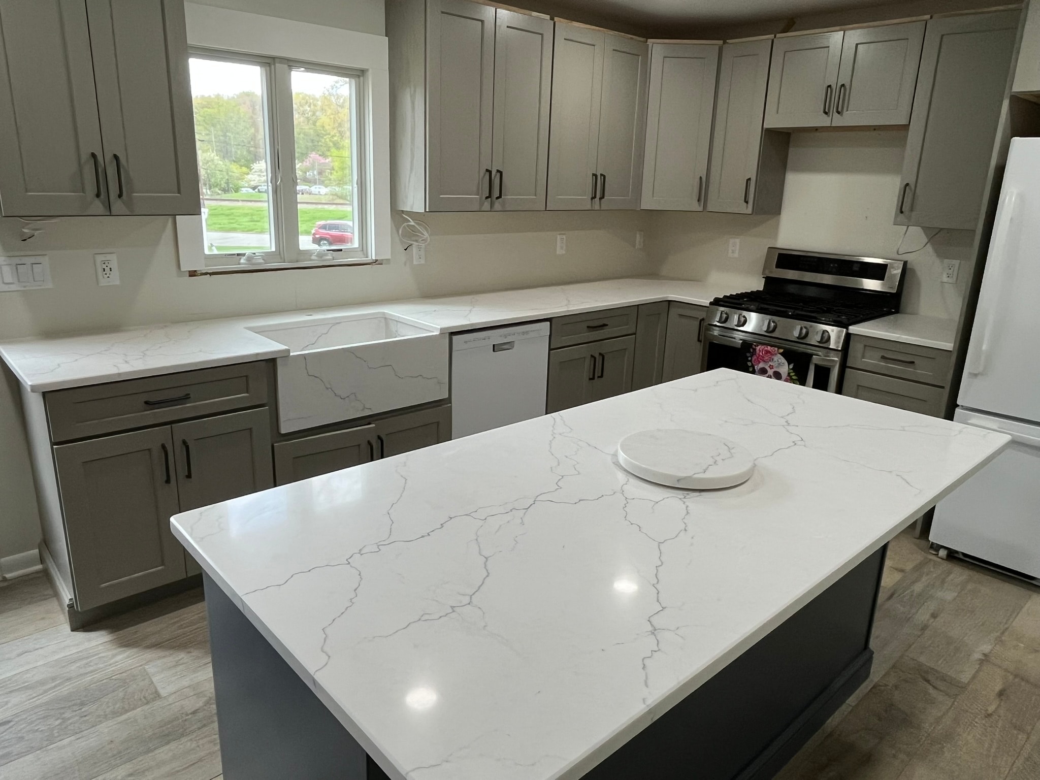 Gray kitchen with white quartz countertops and blue island